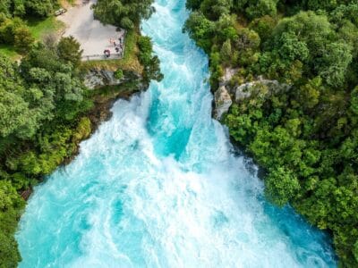 Aerial view of Huka Falls, turquoise water rushing between bush-covered banks near Taupō